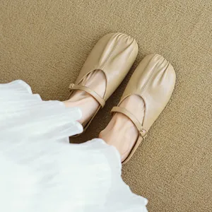 Γαλλικά μπεζ Mary Jane mules με πτυχώσεις και λουράκι πάνω σε υφαντό χαλί