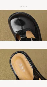 Detailed macro view of black patent leather Mary Jane shoes with brogue perforated texture
