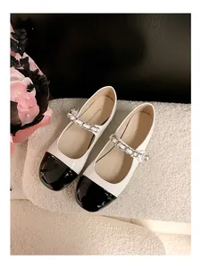 Detail von Mary Jane Ballerinas im französischen Stil mit schwarzer Kappe und Perle