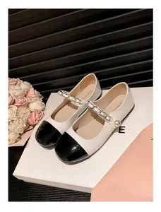 Detailansicht der Mary Jane Schuhe mit schwarzer Lacklederkappe und Perlenkette Dekor