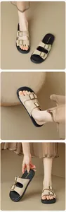 Dettaglio di sandali beige in pelle scamosciata a doppia fascia con fibbie in bronzo e suola