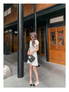 Outdoor-Streetstyle mit weißem Strickkleid und zweifarbigen Mary Jane Ballerinas