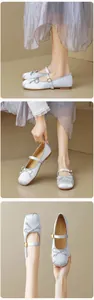 Detail von silbernen Mary Jane Ballerinas aus Satin mit Schleife und goldener Schnalle