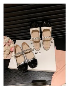 Draufsicht auf zweifarbige Mary Jane Ballerinas mit Perlenkette und kontrastierender Kappe