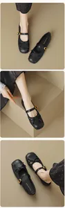 Nahaufnahme schwarzer Mary Jane Ballerinas mit zierlicher Schleife und goldener Schnalle