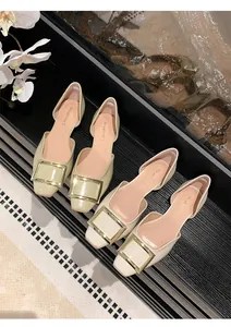 Detailaufnahme quadratischer Ballerinas mit großen Gold schnallen in Grün und Beige