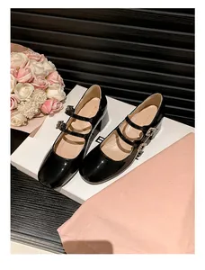 Detail von schwarzen Lackleder Mary Janes mit Doppelriemen und Strass-Schnallen-Verzierung