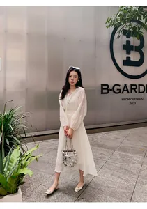 Elegantes weißes Langarmkleid mit Silberstickerei und Pailletten an einem Model präsentiert