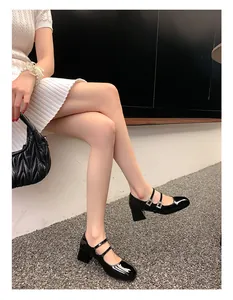 Detail von schwarzen Lackleder-Mary-Janes mit doppelten Kristallschnallen und Blockabsatz
