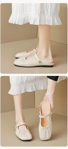 Detail of cream Mary Jane mule featuring ruched leather and gold ball buckle