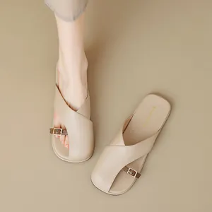 Flache beige Pantoletten mit eckiger Zehenpartie, Kreuzriemen und kleiner Metallschnalle