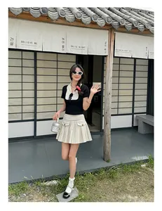 Schickes Damen-Sommerset mit schwarzem Stricktop, Puppenkragen und Faltenmini Rock