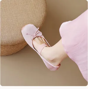 Détail de ballerines roses en soie avec décoration de nœud et sangle élastique souple