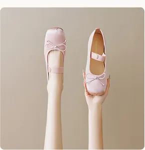 Gros plan sur les ballerines en satin rose avec nœud délicat et bride de cheville élastique