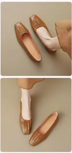 Detail view of brown square-toe flat shoes with pleated leather texture and soft sole
