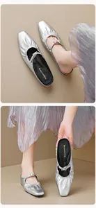 Détail de mules argentées à bout carré avec bride plissée et boucle métallique de luxe