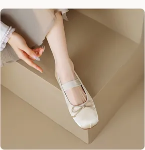 Détail de ballerines Mary Jane en satin beige avec nœud et bride élastique