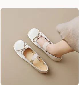 Détail de ballerines à bout rond en satin champagne avec un nœud délicat