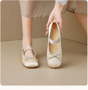 Détail de ballerines en satin champagne avec nœud et bride Mary Jane élastique