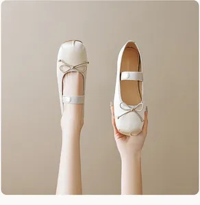 Gros plan de ballerines Mary Jane beige avec nœud délicat et bride élastique