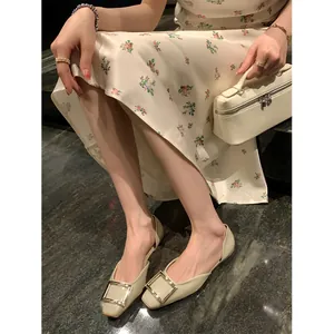 Elegante cremeweiße Ballerinas mit eckiger Zehenkappe und großer goldener Schnalle