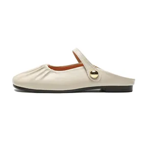 Elegant cream leather flat mule shoes with pleated toe and golden buckle strap on white background