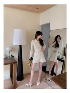 Details des cremeweißen Tweedkleids mit Metallknöpfen und elegantem A-Linien-Schnitt