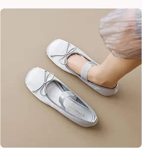 Détail de ballerines en satin argenté avec nœud délicat et bride élastique sur pied