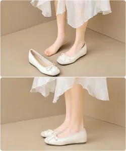 Detalle de bailarinas crema con punta gris en contraste y un delicado lazo decorativo