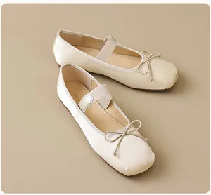 Détail de ballerines crème avec nœud délicat et bride élastique style Babies Mary Jane