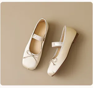 Gros plan de ballerines Mary Jane en satin beige avec nœud délicat et bride élastique