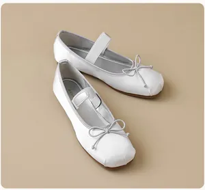 Vue détaillée de ballerines en satin blanc perle avec nœud et bride élastique