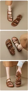 Primer plano de sandalias romanas de cuero marrón con tiras finas y hebillas doradas