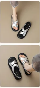Detailed close-up of silver crisscross strap sandals with black elastic heel band