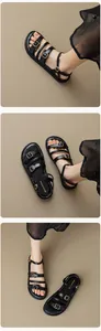 Detalle de sandalias de cuero negro con hebillas doradas y costuras blancas en contraste