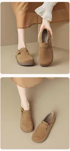 Detail von braunem Wildleder-Clog mit verstellbarer Metallschnalle und weicher Sohle