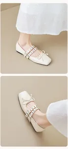 Detail of square-toe cream ballet flats with bow detail and double buckled straps