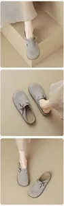 Detailed view of grey suede mule with bronze metal buckle and comfortable round toe