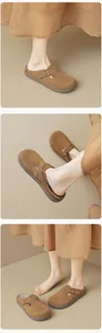 Detail view of dark brown suede mule slippers with bronze buckle and soft platform sole