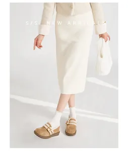 Braune Wildleder-Plateau-Slipper mit Fellkragen zu einem cremefarbenen Strickoutfit