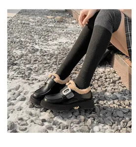 Detalle de mocasines negros de plataforma con forro de pelo sintético y hebilla