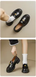 Close-up of black platform loafers featuring elegant gold rose buckles and chunky soles