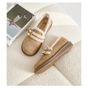 Detailansicht brauner Wildlederclogs mit warmem Lammfellfutter und goldenen Schnallen