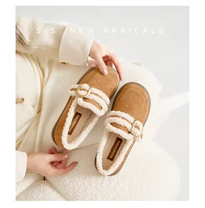 Nahaufnahme brauner Wildleder-Loafer mit weißem Lammfell-Futter und Metallschließe-Detail