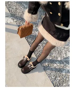 Detalle de mocasines de plataforma marrones con hebilla de metal y forro polar