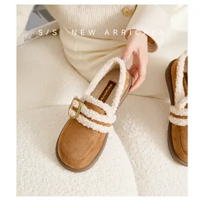 Nahaufnahme brauner Plateau-Loafer mit weißem Fleece-Futter und goldener Schnalle für Damen
