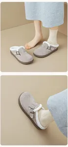 Detail view of grey suede clogs featuring cozy faux shearling lining and metal buckle strap