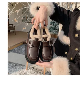 Detalle de mocasines de cuero marrón oscuro con forro de piel sintética beige y hebilla