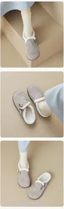 Detail of grey suede mule with metal buckle and warm faux shearling lining