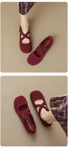 Macro detail of burgundy suede Mary Jane flat shoes with cross straps and round toe
